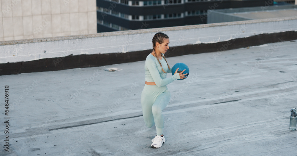 Sports, medicine ball and woman athlete in the city for a health, wellness and cardio workout or exercise. Fitness, energy and young female person training on building rooftop in urban town.