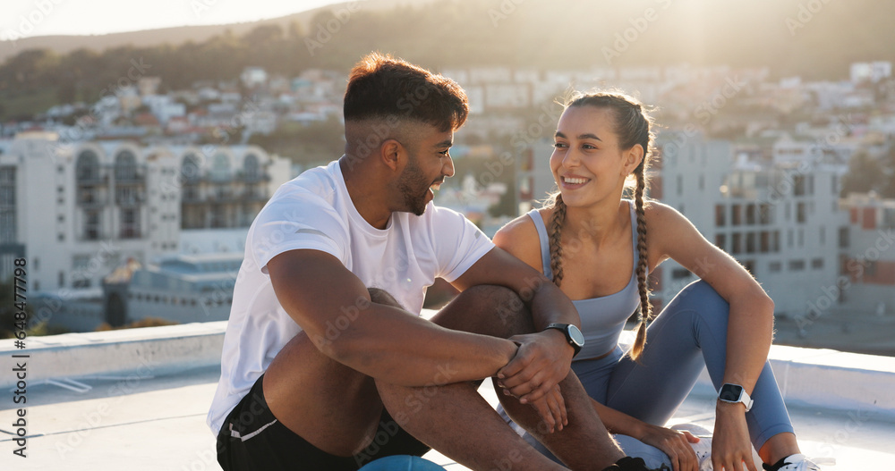 Couple, fitness and city to rest and talk for exercise, workout or training together on rooftop. Happy man and woman on sports break with a laugh, communication or conversation about wellness