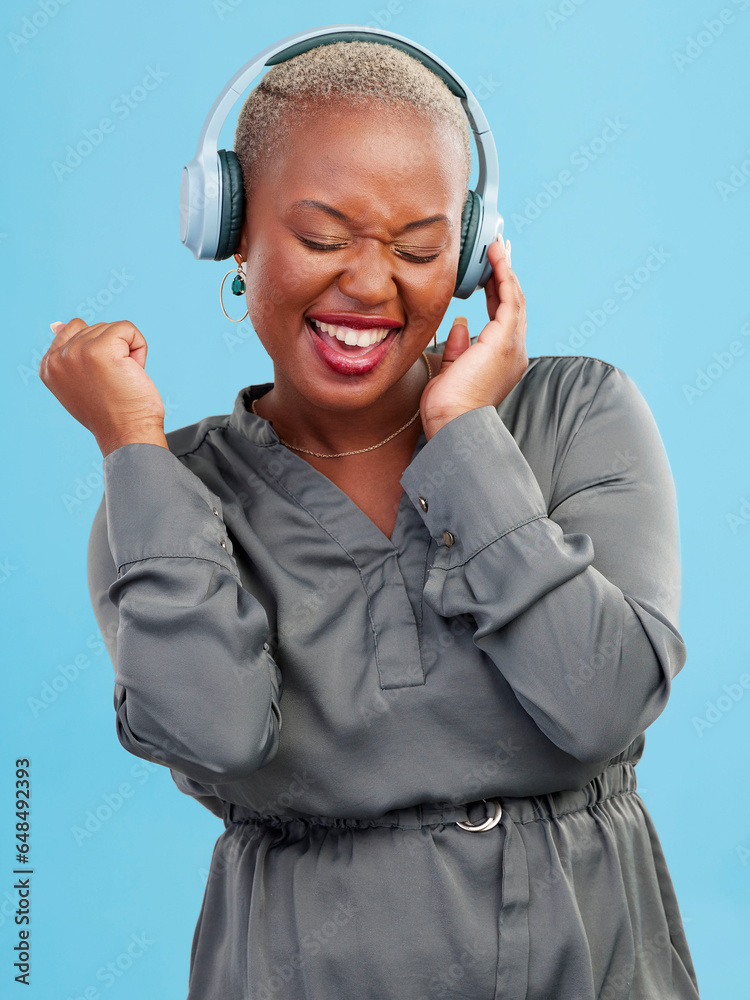 Happy black woman, headphones and listening to music, audio track or sound against a studio background. Excited African female person smile enjoying podcast, streaming or entertainment on headset