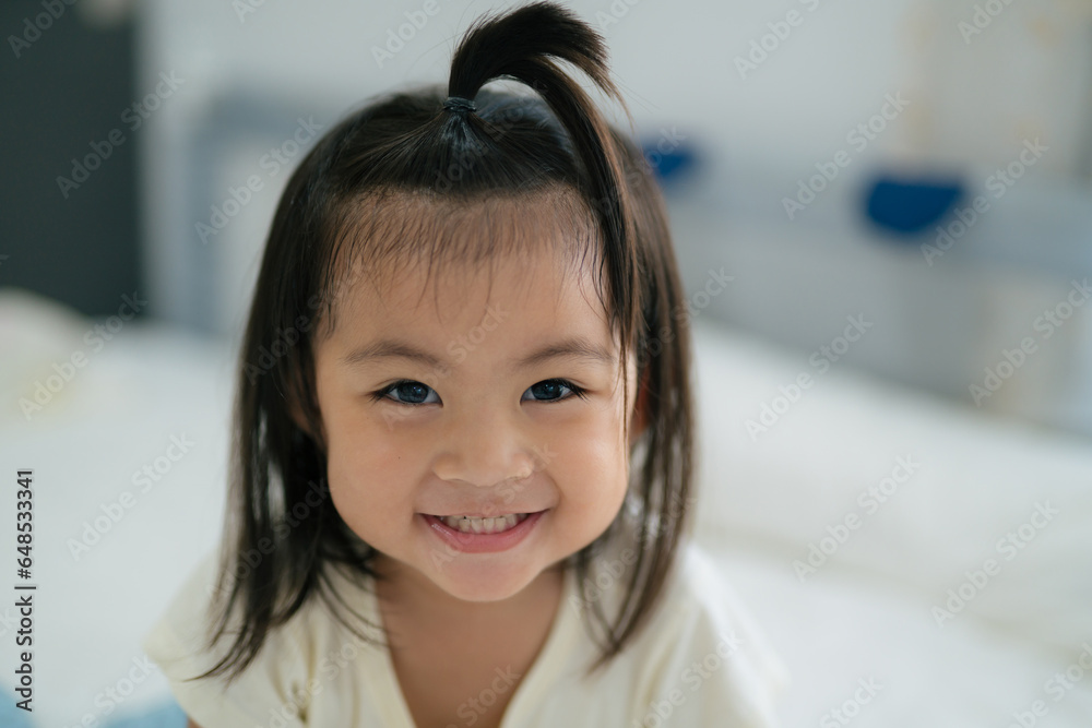 Asian child cute girl smiling while looking at the camera at home.