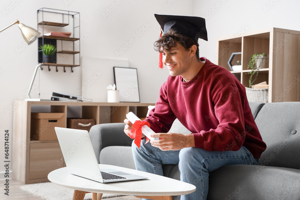 Male graduate student with diploma video chatting at home