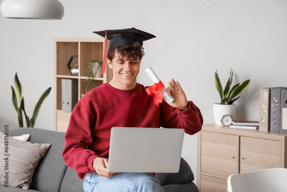 Male graduate student with diploma video chatting at home