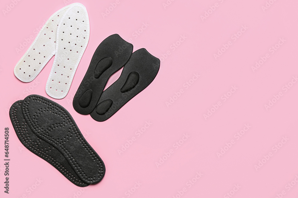 Different orthopedic insoles on pink background