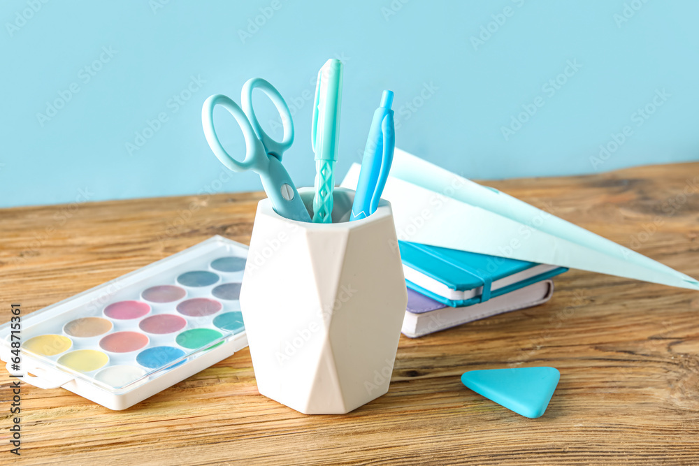 Set of stationery with paper plane on wooden table