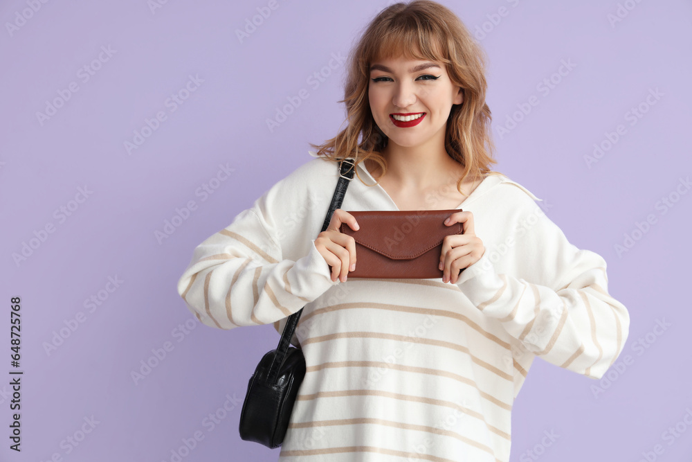 Young woman with wallet on lilac background