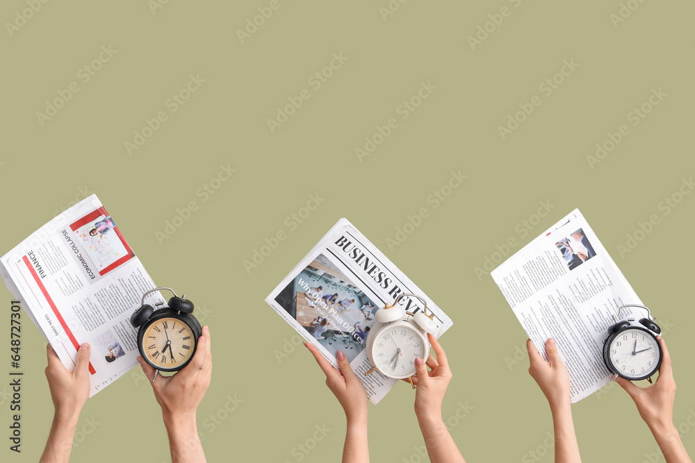 Hands holding different alarm clocks and newspapers on green background