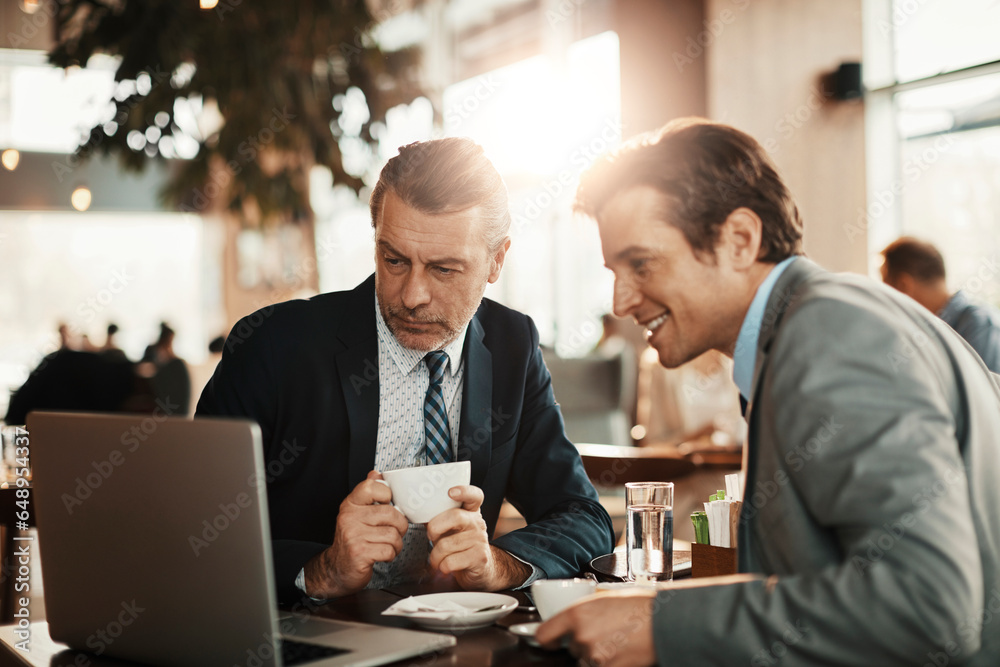 Two middle aged businessmen having a meeting in a cafe decorated for christmas and the new year holidays