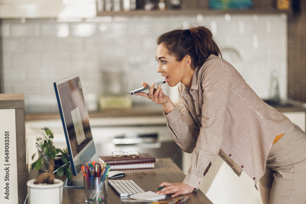 Woman Using Smartphone While Working At Home