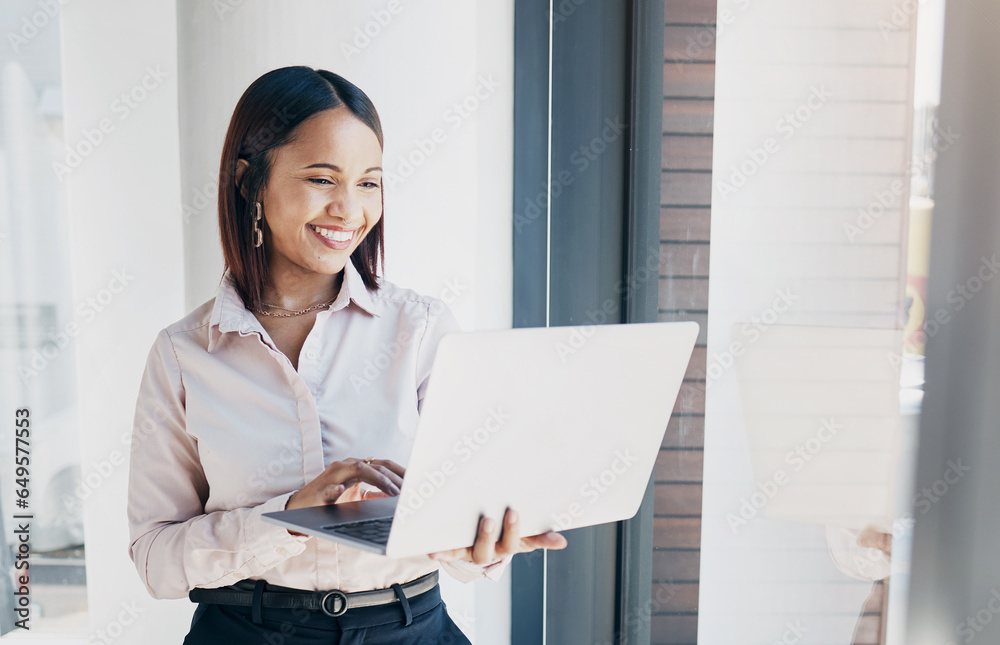 Happy woman at office window, with laptop and reading email research, schedule or online for feedback. Internet, networking or communication on website, businesswoman smile at human resources agency