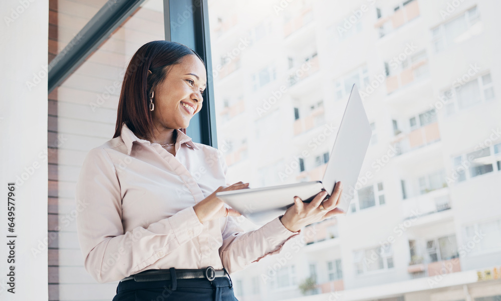 Happy woman at office window, holding laptop and reading email, schedule or online for feedback. Internet, networking or communication on website, businesswoman at human resources agency at low angle