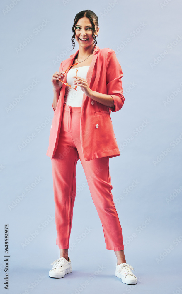 Fashion, portrait and suit, happy woman in studio with makeup, confidence and body in suit. Beauty, style and influencer girl in designer clothes, trendy promo and model standing on blue background