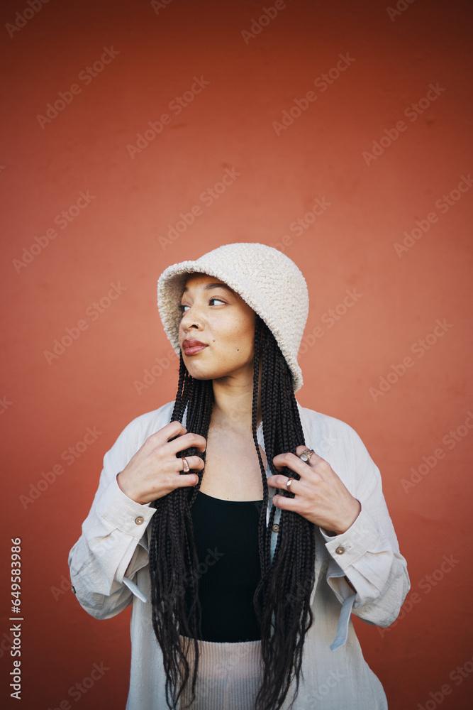 Fashion, clothes and woman in city on orange background with trendy outfit, cool clothing and style for glamour. Beauty, mockup space and person by wall with confidence, pride and cosmetics in town