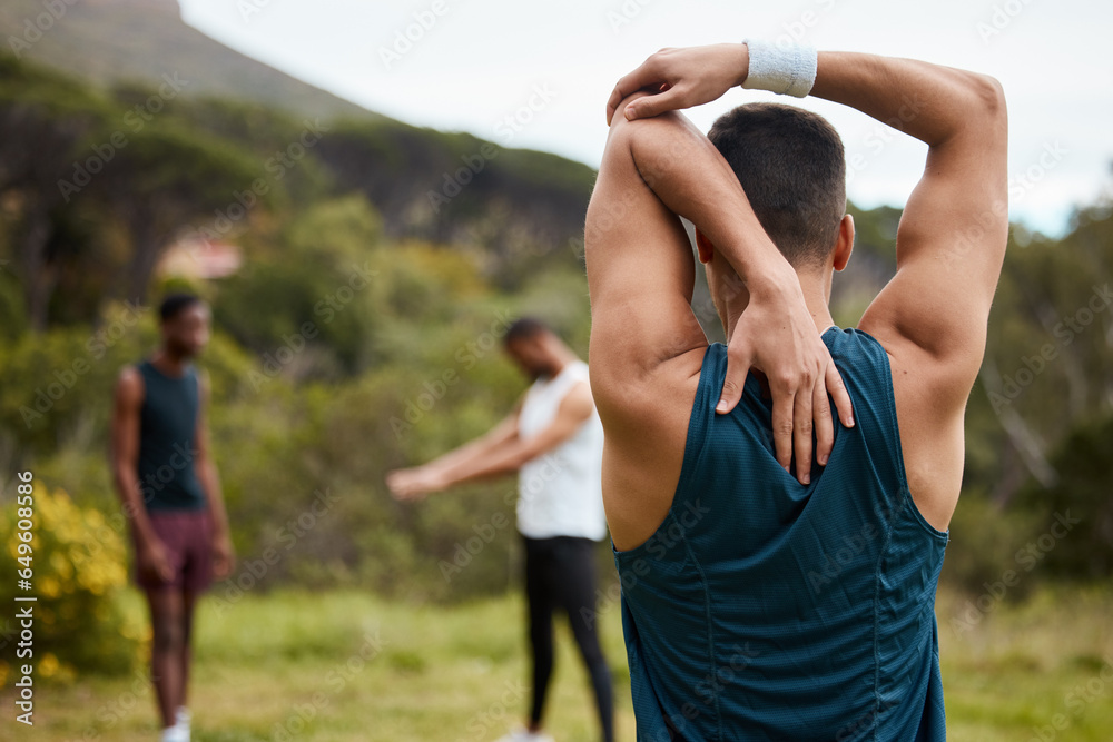 Stretching arm, fitness and exercise with a man outdoor for health and wellness. Behind runner, athlete or sports person in nature park to start morning run, workout or training with muscle warm up