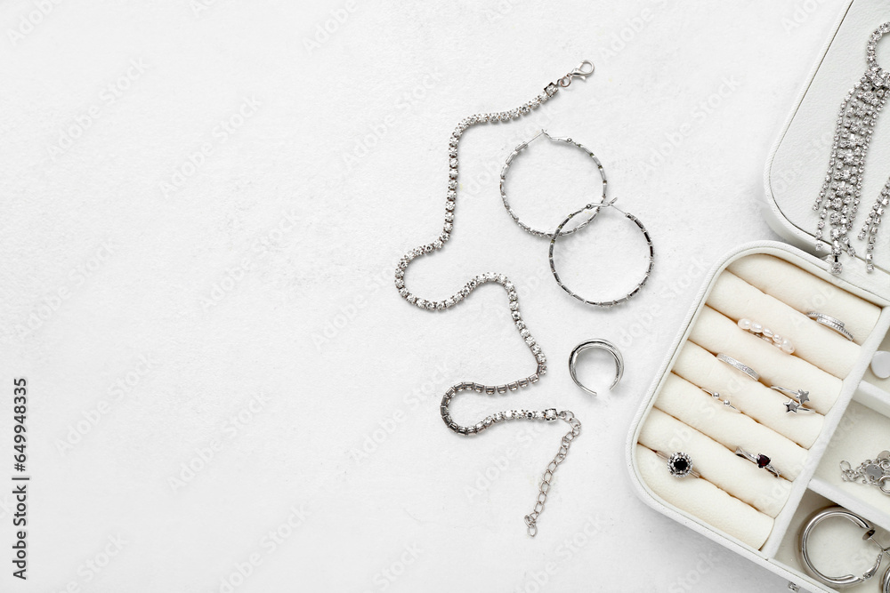 Opened organizer with stylish jewelry on white background