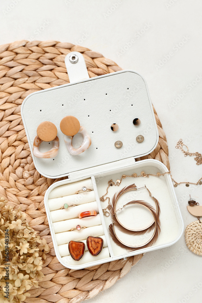 Wicker mat with organizer and stylish jewelry on white background