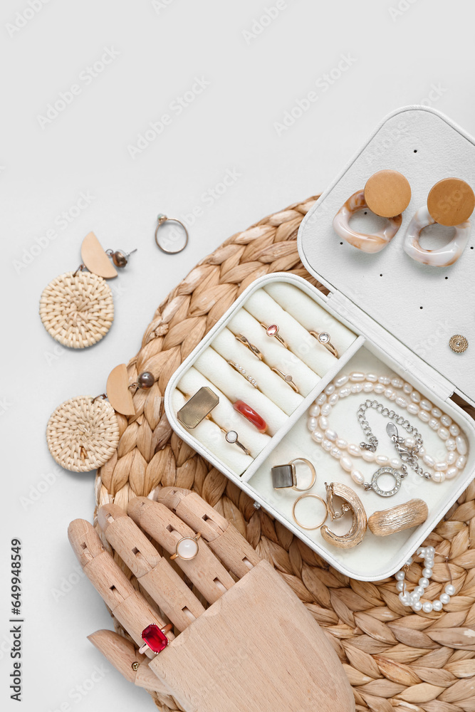 Wooden hand and organizer with stylish jewelry on white background