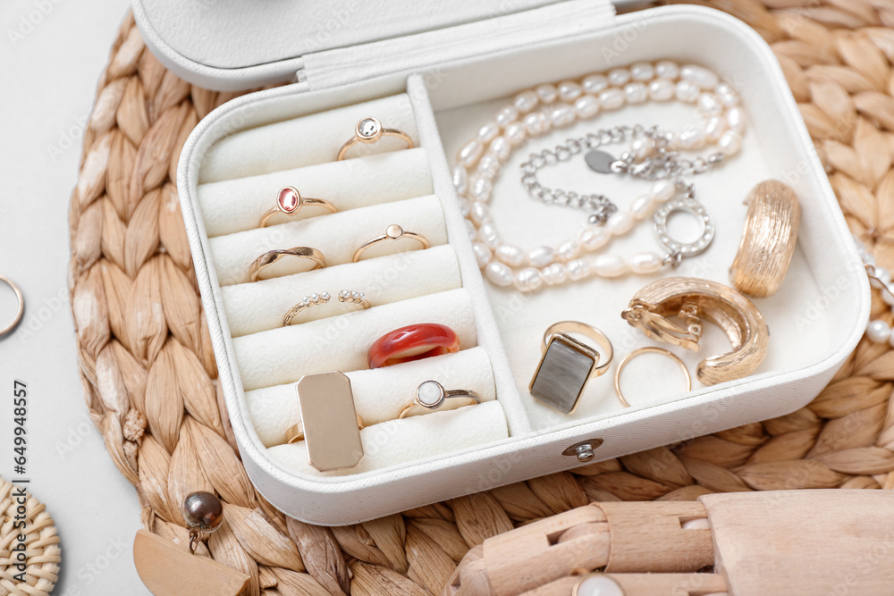 Wooden hand and organizer with stylish jewelry on white background