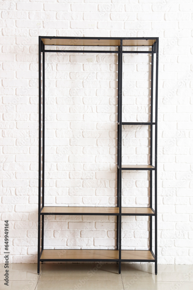 Empty shelving unit near white brick wall in room