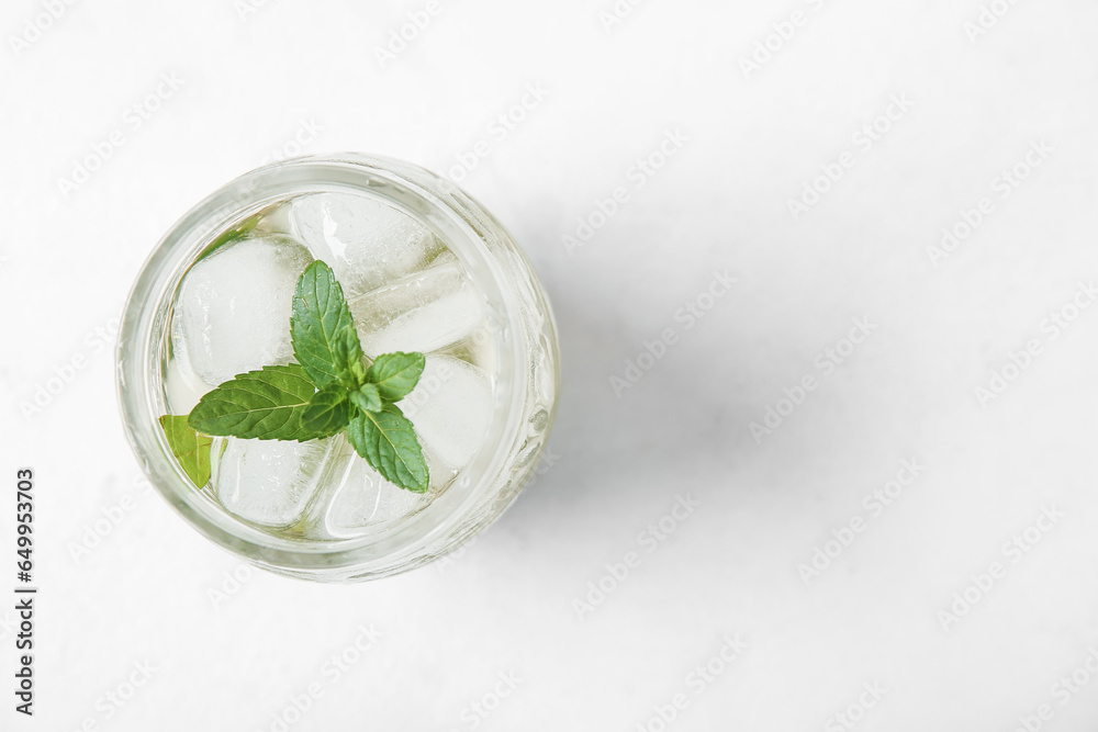 Glass of fresh icy mint tea on white background