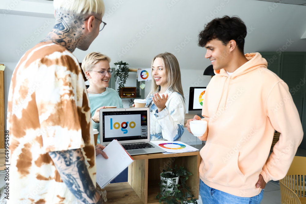 Team of graphic designers with cups of coffee working in office