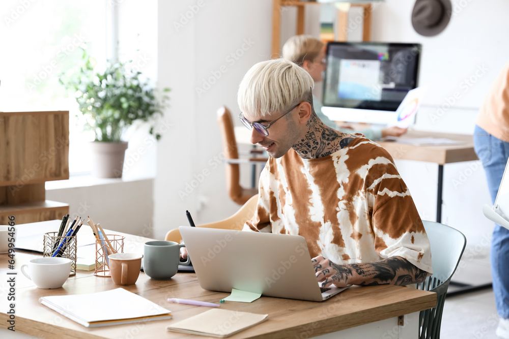 Male graphic designer working with tablet at table in office