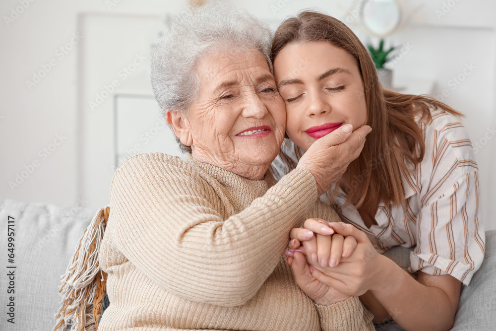 Young woman with her grandmother holding hands at home