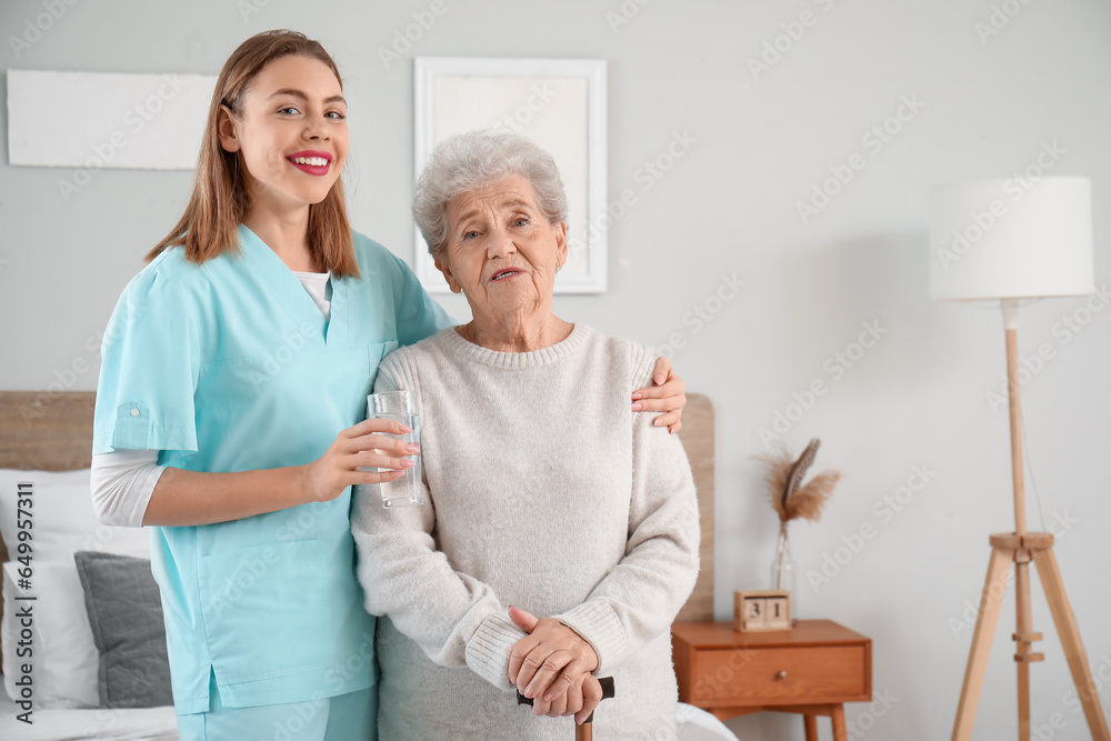 Female caregiver with senior woman in bedroom