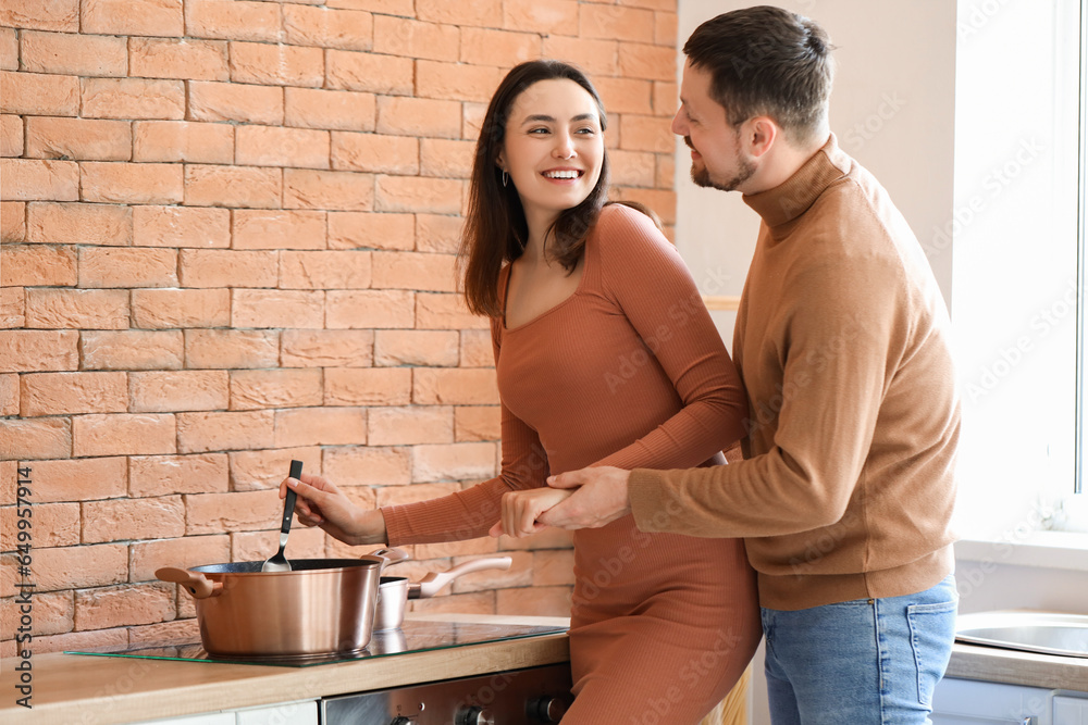 Happy young couple cooking in kitchen