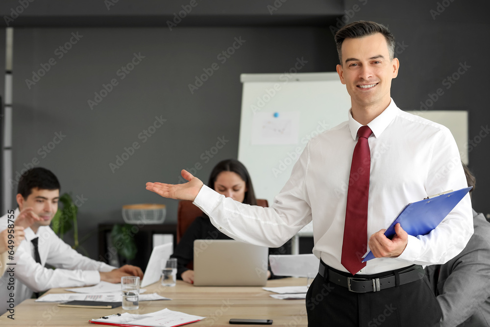 Male business consultant with clipboard working in office