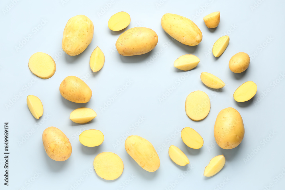 Frame made of raw potatoes on blue background