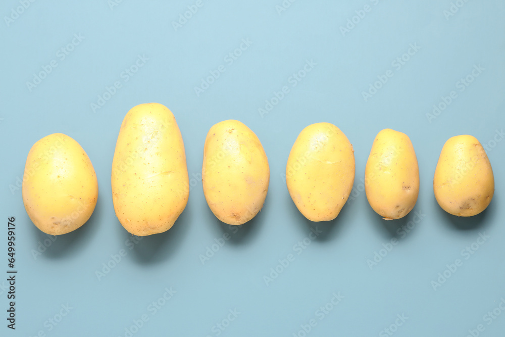 Raw potatoes on blue background