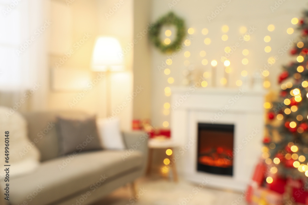 Blurred view of festive living room with fireplace, glowing lights and Christmas tree