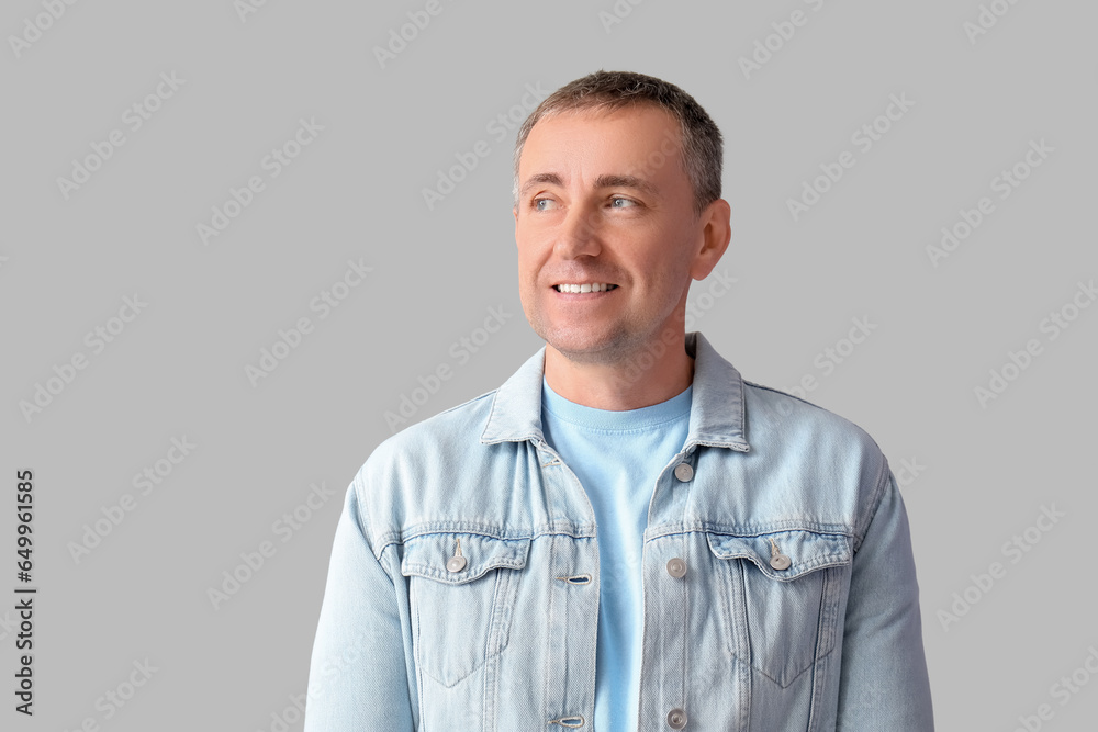 Portrait of thoughtful mature man looking somewhere on grey background