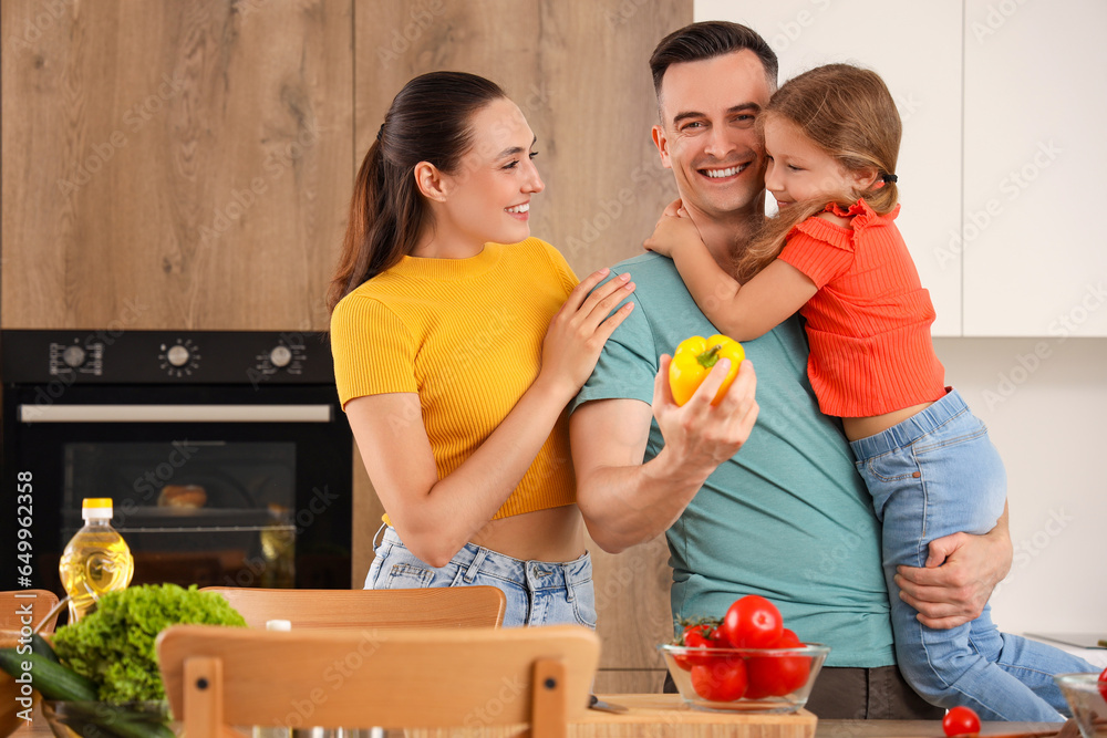 Happy parents with their little daughter cooking in kitchen