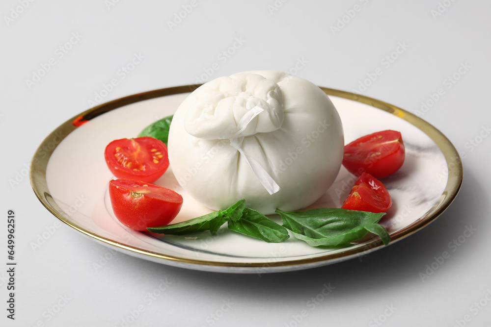 Plate with tasty Burrata cheese on grey background