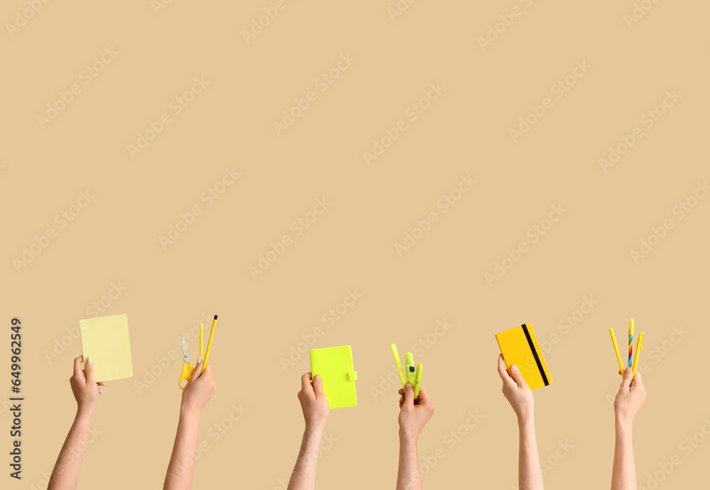 Hands with school supplies on beige background