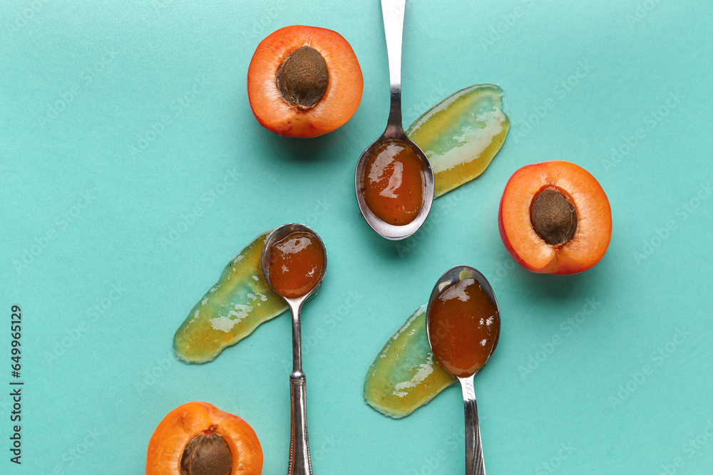 Metal spoons with sweet apricot jam on green background