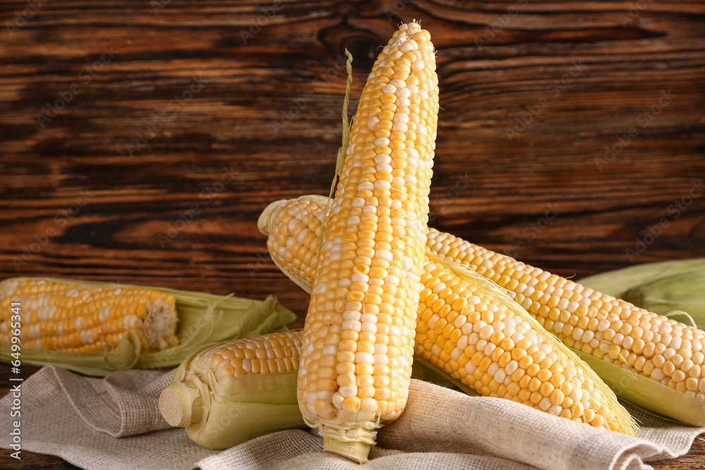 Fresh corn cobs on wooden background