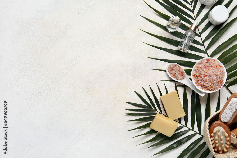 Composition with bath supplies and palm leaves on light background