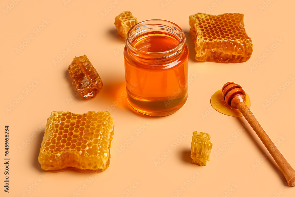 Jar with sweet honey and combs on orange background