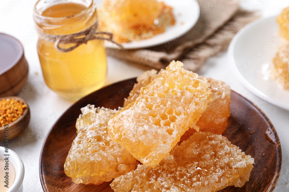 Plate with sweet honeycombs on table, closeup