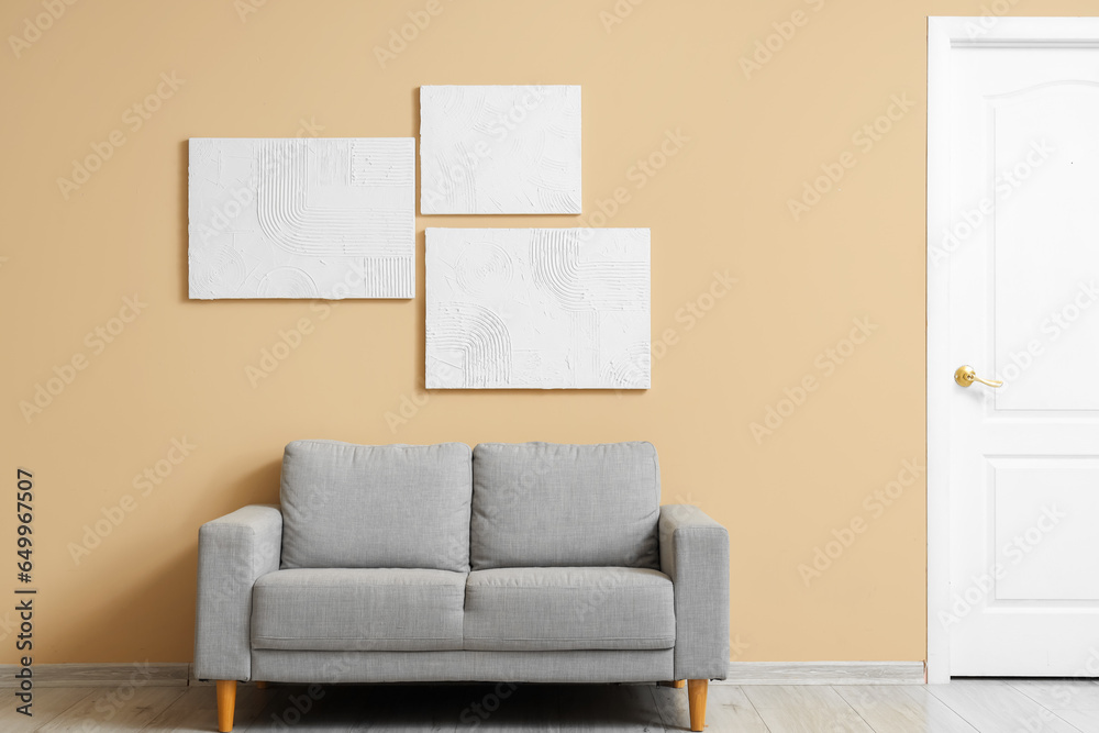 Interior of living room with grey sofa and paintings