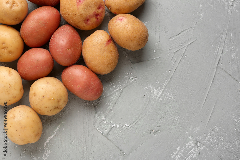 Fresh raw potatoes on grey background