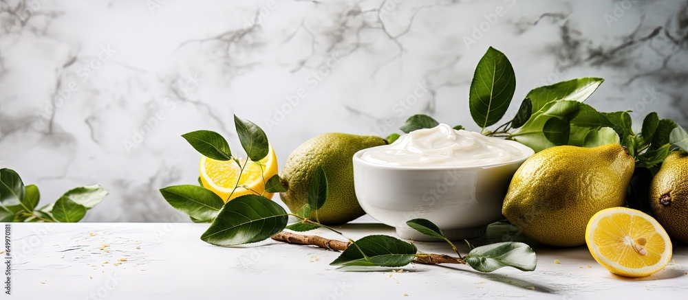 Ingredients for organic cosmetic cream avocado honey lemon and eucalyptus on a white stone background used for face and body care in harsh sunlight