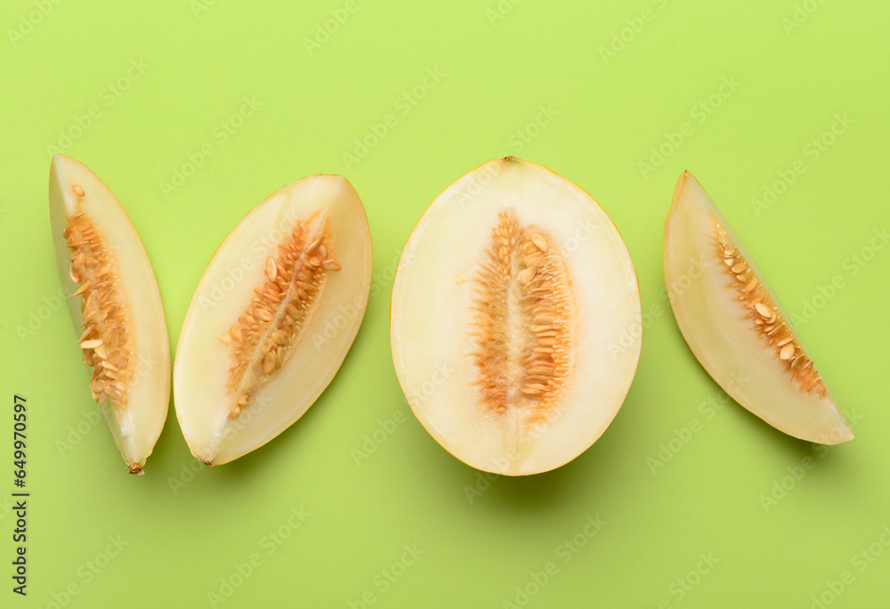 Pieces of sweet melon on green background