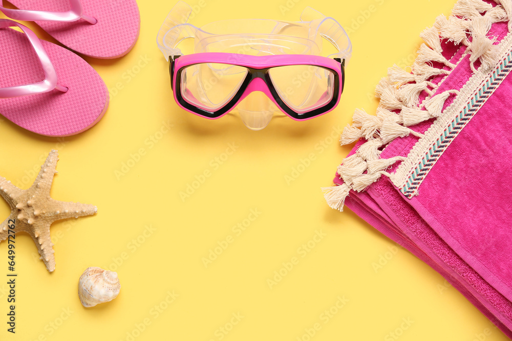 Swimming mask, flip flops, towel and seashell on yellow background