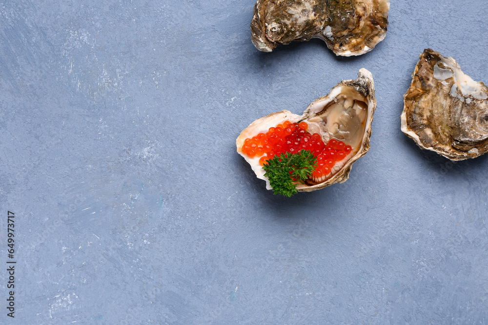 Tasty oysters with red caviar on blue background