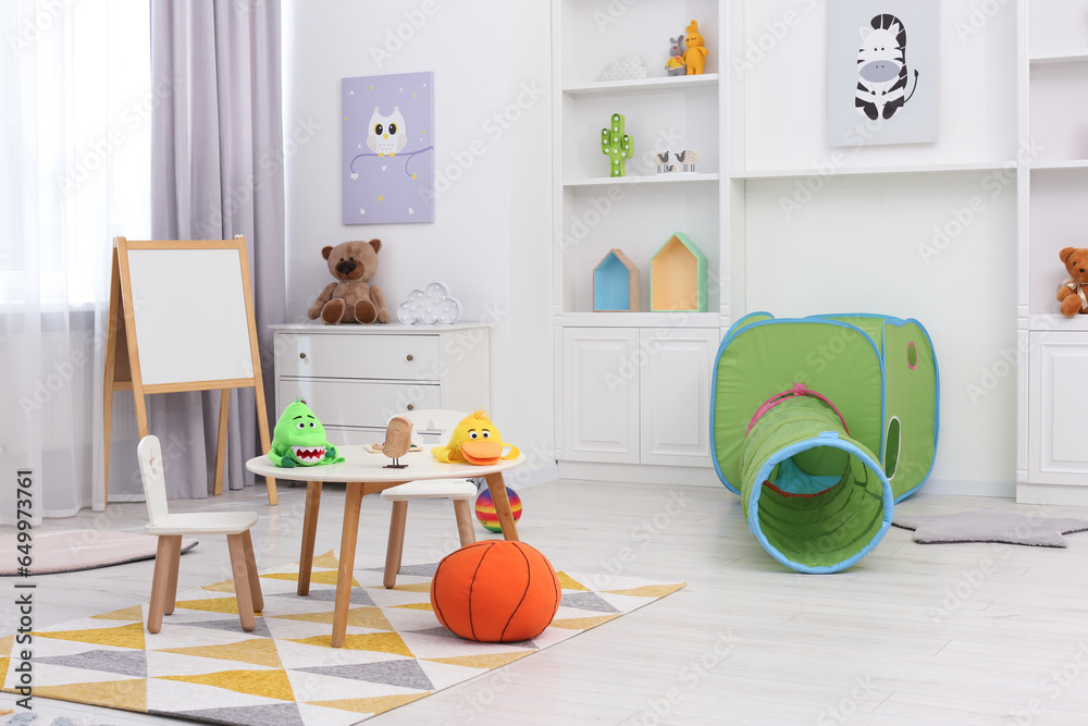 Child`s playroom with different toys and modern furniture. Stylish kindergarten interior