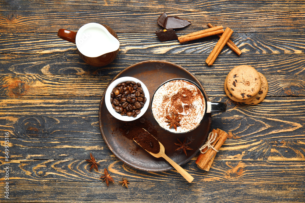 Cup of tasty coffee with cinnamon, beans and cookies on wooden background