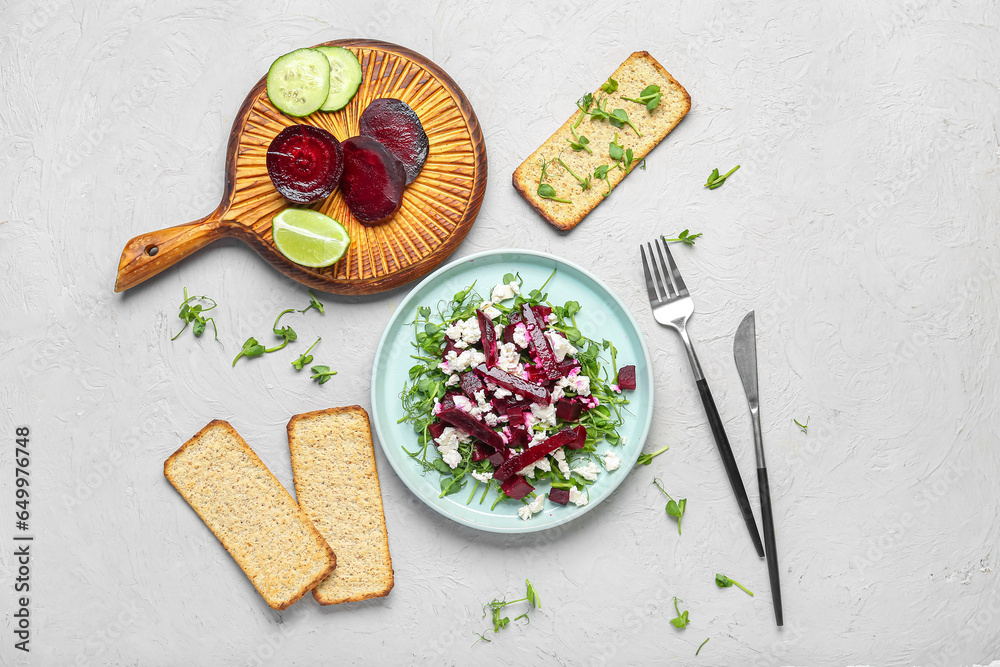 Plate of fresh vegetable salad with beet, crackers and lime on white background